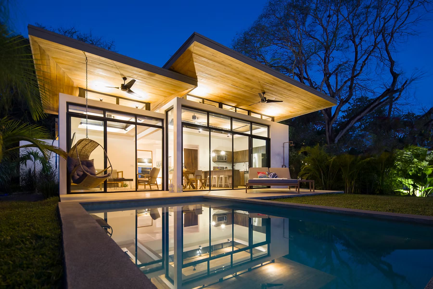 Villa lit up at dusk by the pool